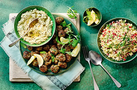 Make your own succulent lamb meatballs with this easy recipe. Served with jewelled couscous salad and silky homemade hummus, it's an impressive looking spread that's perfect for leaving leftovers for meatball wraps.