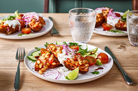 Baked sweet potatoes are filled with a wonderful mix of beans, peppers, onions and cheese and baked until golden in this nourishing midweek meal